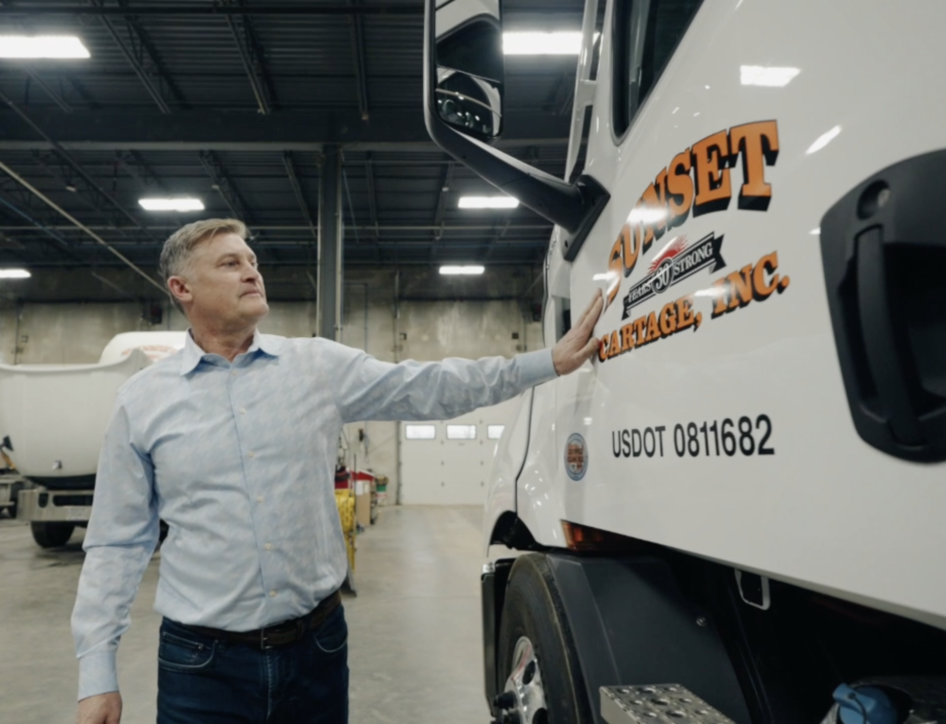 Donald J. Mueller, CEO of Sunset Materials & Logistics looks over one of the Sunset  fleet trucks.